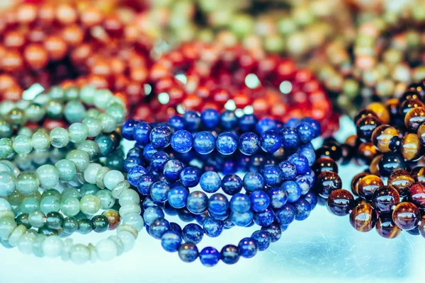 La pietra colorata viene utilizzata per fare bellissimi braccialetti. È una credenza religiosa del popolo thailandese che avrà buona fortuna per la vendita sul mercato locale a Kanchanaburi, Thailandia. Focus selettivo . — Foto Stock