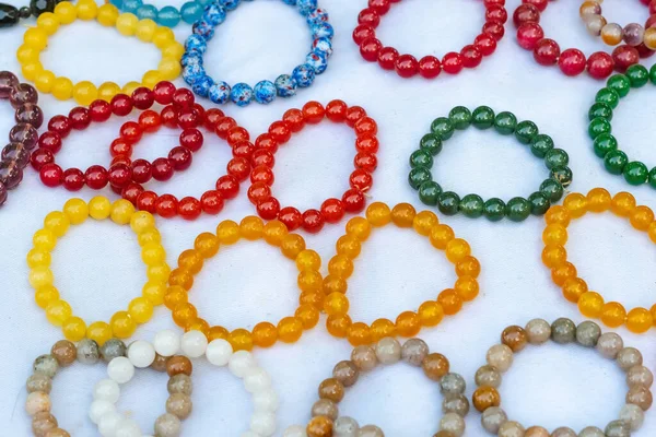 La pierre colorée est utilisée pour fabriquer de beaux bracelets. Est une croyance religieuse du peuple thaïlandais qui aura de la chance à vendre sur le marché local à Kanchanaburi, Thaïlande. Concentration sélective . — Photo