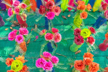 Plastik şişelerden yapılmış renkli plastik çiçekler bahçedeki çiçek süsü olarak kullanılıyor. Plastik şişe geri dönüştürüldü.