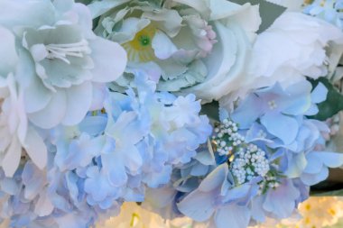 Yapay mavi ve beyaz çiçekler kemeri düğün arkaplanı olarak süsler. Çiçek arka planı. Seçici odak.