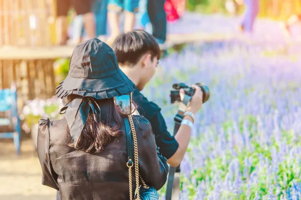 Mutluluk Turistleri Maple Garden 'da öğleden sonra çiçek açan güzel çiçeklerle fotoğraf çekerler. Kanchanaburi, Tayland 'da.