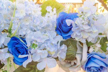 Yapay mavi ve beyaz çiçekler kemeri düğün arkaplanı olarak süsler. Çiçek arka planı. Seçici odak.