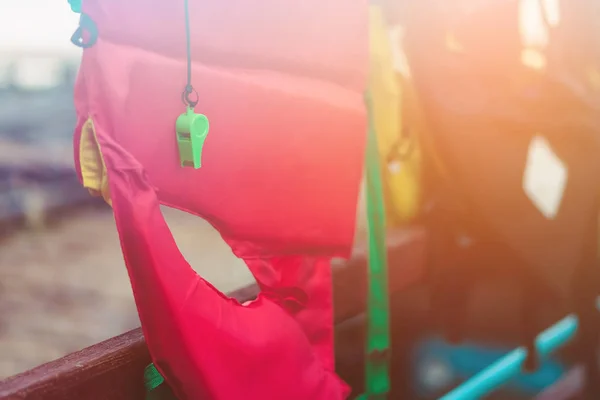 Un silbato verde con chaleco salvavidas rojo colgado en la barandilla alrededor de la pasarela para proteger a los pasajeros en los muelles. — Foto de Stock