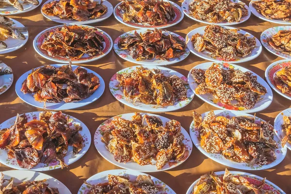 Many kinds of deep fried fish on dish for sale at street food in Thailand.