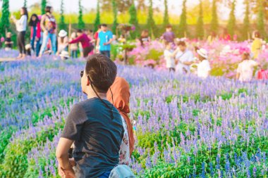 Mutluluk Turistleri Maple Garden 'da öğleden sonra çiçek açan güzel çiçeklerle fotoğraf çekerler. Kanchanaburi, Tayland 'da.