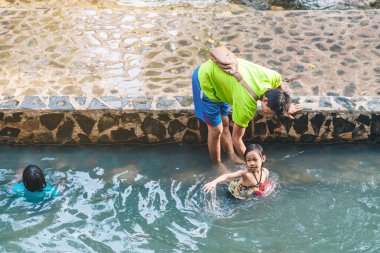 KANCHANABURI, THAILAND - 1 Ocak 2020 'de Kanchanaburi, Tayland' da kimliği belirlenemeyen Asyalı turistler cesedi sıcak maden suyuna batırıp sağlık için Hindad Hotspring 'te yıkandılar..