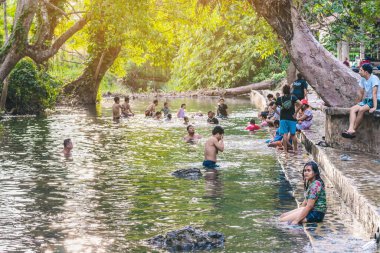 KANCHANABURI, THAILAND - 1 Ocak 2020 'de Kanchanaburi, Tayland' da kimliği belirlenemeyen Asyalı turistler cesedi sıcak maden suyuna batırıp sağlık için Hindad Hotspring 'te yıkandılar..