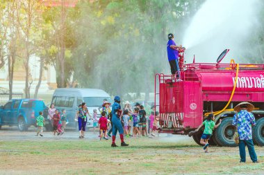 Kanchanaburi, Tayland - 17 Nisan 2019 'da Tayland' ın Kanchanaburi kentinde 17 Nisan 2019 'da yapılan tapınakta Songkran festivali sırasında bir itfaiye aracında duran kimliği belirsiz itfaiyeci insanların üzerine su döktü..