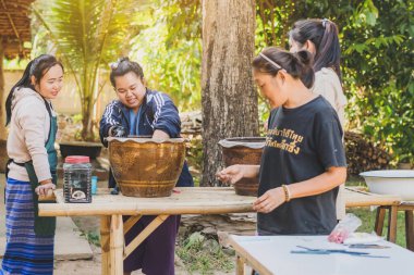 LAMPHUN THAILAND - 12 ARALIK: tanımlanamayan Taylandlı kadın turistler, Tayland 'ın Lamphun kentindeki Karen köyünde 12 Aralık 2019 tarihinde kravat boyası yapmayı öğreniyorlar.