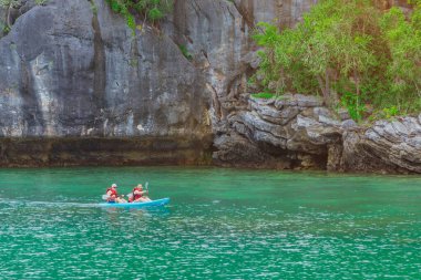 Ang Thong Deniz Parkı, Samui, Tayland - 13 Ekim 2019: Idyllic turkuaz okyanusunda kayak yapan turistler, Ang Thong Ulusal Deniz Parkı 'ndaki yeşil orman ağaçları ve kireç taşı dağlarıyla adanın yakınını keşfetmek için.
