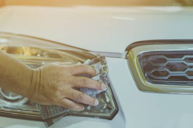 Erkek işçiye yakın mesafede, arabanın cam kısmını temizlemek için ıslak gazeteler kullanın. Eldeki seçici odaklanma.