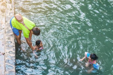 KANCHANABURI, THAILAND - 1 Ocak 2020 'de Kanchanaburi, Tayland' da kimliği belirlenemeyen Asyalı turistler cesedi sıcak maden suyuna batırıp sağlık için Hindad Hotspring 'te yıkandılar..