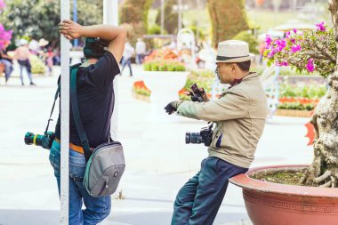 DALAT- VIETNAM, APRIL 27,2019: Tanımlanamayan iki erkek fotoğrafçı 27 Nisan 2019 'da Dalat, Vietnam' da Dalat Çiçek Bahçeleri 'nde fotoğraf çekmek için müşterilerini bekliyor.