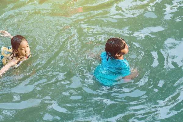 KANCHANABURI, THAILAND - 1 Ocak 2020 'de Kanchanaburi, Tayland' da kimliği belirlenemeyen Asyalı turistler cesedi sıcak maden suyuna batırıp sağlık için Hindad Hotspring 'te yıkandılar..