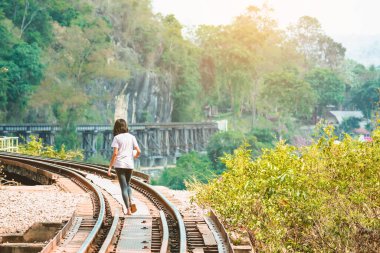 İkinci Dünya Savaşı 'nda Krasae mağarasında yürüyen mutlu kız ve Ölüm Demiryolu Köprüsü Tayland' dan Myanmar 'a giden Kwai Noi Nehri üzerinden.