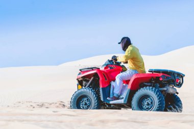 Turistler dörtlü bisiklete binmeyi ya da Mui Ne, Vietnam 'daki beyaz kum tepelerinde dört teker çekişli güçlü ATV' lere binmeyi severler..