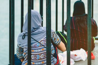 Müslüman kadınların arka planı rahatlar ve Kanchanaburi, Tayland 'daki Kwai Köprüsü' nün güzel manzarasına hayran kalır..