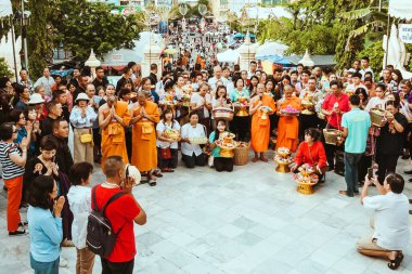 NAKHON THAILAND - NOVEMBER 16: Kimliği belirlenemeyen Tayland rahipleri, Tayland 'ın Nakhon Pathom kentinde Kasım 16.2019' da Wat Phra Pathommachedi 'de yapılan dini bir sadaka töreni olarak fakir / görgü tanıklarına kurdele-çiçek verdi.