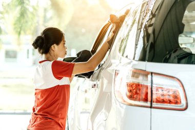 KANCHANABURI THAILAND - 27 Ekim 2019 'da Tayland' ın Kanchanaburi kentindeki PT benzin istasyonunda mikrofiberle kimliği belirlenemeyen Taylandlı kadın araba parlatıcısını temizledi.