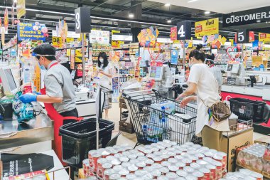KANCHANABURI, THAILAND - 6 Nisan 2020: Kanchanaburi, Tayland 'daki Top Supermarket' te mikropların (Covid-19) yayılmasını önlemek için tanımlanamayan kasiyer veya süpermarket personeli ve tıbbi koruyucu maskeli müşteriler.