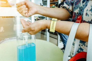 Kadın, şehirde elini temizlemek için el dezenfektanı şişesine basıyor. Grip virüsü, Covid-19 (Coronavirus hastalığı). Alkol jeli şişesine odaklan.