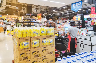 KANCHANABURI, THAILAND - 6 Nisan 2020: Kanchanaburi, Tayland 'daki Top Supermarket' te mikropların (Covid-19) yayılmasını önlemek için tanımlanamayan kasiyer veya süpermarket personeli ve tıbbi koruyucu maskeli müşteriler.