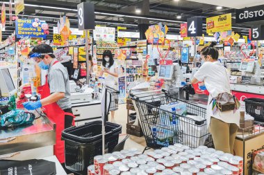 KANCHANABURI, THAILAND - 6 Nisan 2020: Kanchanaburi, Tayland 'daki Top Supermarket' te mikropların (Covid-19) yayılmasını önlemek için tanımlanamayan kasiyer veya süpermarket personeli ve tıbbi koruyucu maskeli müşteriler.