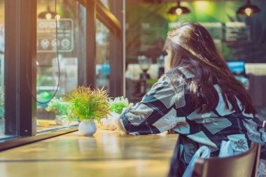 Dekorasyon için masanın üzerindeki yapay bitkiler veya plastik ağaçlar ve kahve dükkanındaki müşteriler için hoş geldin..
