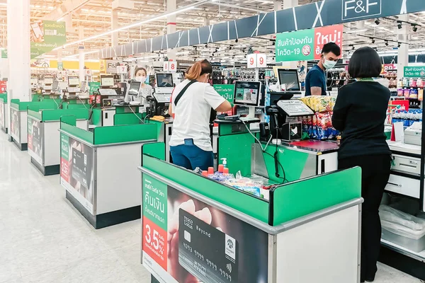 KANCHANABURI, THAILAND - APRIL 12,2020: Coronavirus (covid -2019) için yüz koruması takan kimliği belirsiz müşteriler ve 12 Nisan 2020 tarihinde Kanchanaburi, Tayland 'da Tesco Lotus' ta alışveriş.