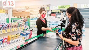 KANCHANABURI, THAILAND - APRIL 12,2020: Coronavirus (covid -2019) için yüz koruması takan kimliği belirsiz müşteriler ve 12 Nisan 2020 tarihinde Kanchanaburi, Tayland 'da Tesco Lotus' ta alışveriş.