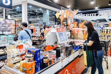 KANCHANABURI, THAILAND - 6 Nisan 2020: Kanchanaburi, Tayland 'daki Top Supermarket' te mikropların (Covid-19) yayılmasını önlemek için tanımlanamayan kasiyer veya süpermarket personeli ve tıbbi koruyucu maskeli müşteriler.