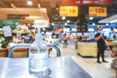 Corona virüsünün yayılmasını önlemek için el temizliği için alkol jeli şişelerini temizleyin (Covid-19). Süpermarketten almadan önce müşteriler için giriş servisini yerleştir.