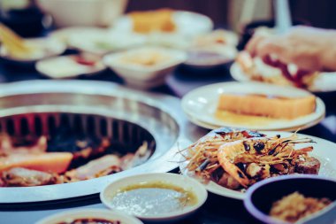 İnsanlar bir restoranda dumansız barbekü ızgara et ızgara. Karideslere seçici odaklanma.