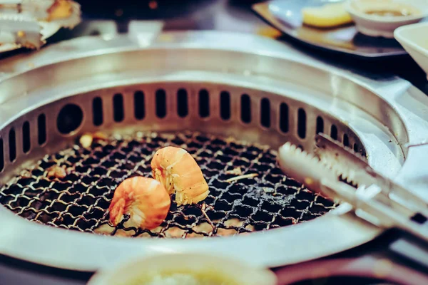 レストランで無煙のバーベキューグリルで肉を焼く人々 エビの選択的な焦点 — ストック写真
