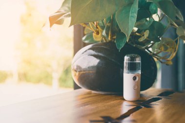 Corona virüsünün (Covid-19) kahve dükkanından almadan önce müşterilere hizmet etmek üzere masaya konmasını önlemek için el temizleme için alkol nano sis spreyi. Modern sağlık teknolojisi.