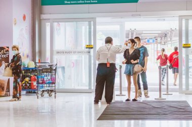 KANCHANABURI, THAILAND - 6 Nisan 2020: Kimliği belirlenemeyen memur, 6 Nisan 2020 'de Kanchanaburi, Tayland' daki Robinson Alışveriş Merkezi 'nde humma için koronavirüs ya da COVID-19 salgını olarak termometre taraması uygula.