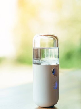 Corona virüsünün (Covid-19) kahve dükkanından almadan önce müşterilere hizmet etmek üzere masaya konmasını önlemek için el temizleme için alkol nano sis spreyi. Modern sağlık teknolojisi.