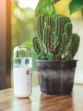 Corona virüsünün (Covid-19) kahve dükkanından almadan önce müşterilere hizmet etmek üzere masaya konmasını önlemek için el temizleme için alkol nano sis spreyi. Modern sağlık teknolojisi.