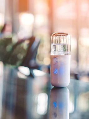 Corona virüsünün (Covid-19) kahve dükkanından almadan önce müşterilere hizmet etmek üzere masaya konmasını önlemek için el temizleme için alkol nano sis spreyi. Modern sağlık teknolojisi.