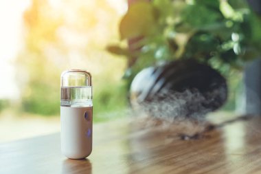 Corona virüsünün (Covid-19) kahve dükkanından almadan önce müşterilere hizmet etmek üzere masaya konmasını önlemek için el temizleme için alkol nano sis spreyi. Modern sağlık teknolojisi.