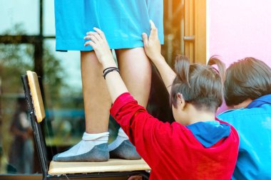 Bayan öğrencilerin arka planı, okuldaki ıslak gazetelerle bardağı silmeye yardımcı oluyor..