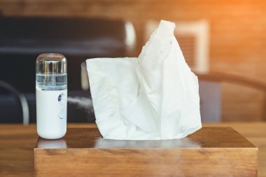 Corona virüsünün (Covid-19) kahve dükkanından almadan önce müşterilere hizmet etmek üzere masaya konmasını önlemek için el temizleme için alkol nano sis spreyi. Modern sağlık teknolojisi.