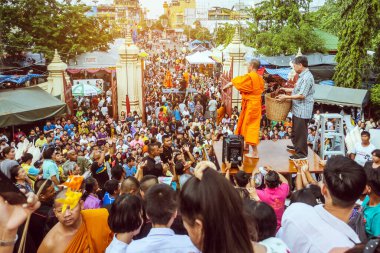 NAKHON THAILAND - NOVEMBER 16: Kimliği belirlenemeyen Tayland rahipleri, Tayland 'ın Nakhon Pathom kentinde Kasım 16.2019' da Wat Phra Pathommachedi 'de yapılan dini bir sadaka töreni olarak fakir / görgü tanıklarına kurdele-çiçek verdi.