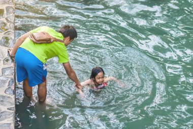 KANCHANABURI, THAILAND - 1 Ocak 2020 'de Kanchanaburi, Tayland' da kimliği belirlenemeyen Asyalı turistler cesedi sıcak maden suyuna batırıp sağlık için Hindad Hotspring 'te yıkandılar..