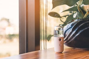 Corona virüsünün (Covid-19) kahve dükkanından almadan önce müşterilere hizmet etmek üzere masaya konmasını önlemek için el temizleme için alkol nano sis spreyi. Modern sağlık teknolojisi.