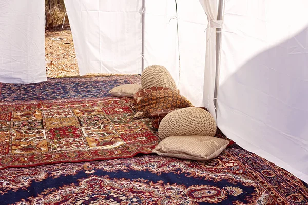 Çadır halılar ve yastıklarla dolu.