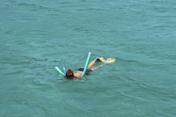 Γυναίκα snorkeling πάνω από ένα κοραλλιογενή ύφαλο χρησιμοποιώντας αφρό πλευστότητας — Φωτογραφία Αρχείου