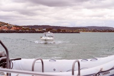 Limanı terk eden küçük bir tekne Turist Katamaran 'ın arkasında