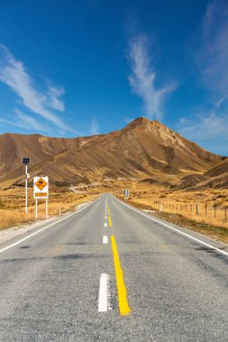 Uzun düz asfalt karayolu Yeni Zelanda geçişte Lindis içine