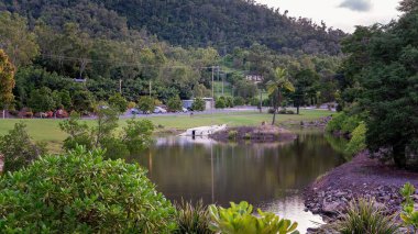 Küçük bir gölde batık bir tekne. Etrafı otopark ve bahçelerle çevrili.
